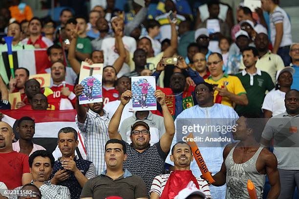 Fans hold photos of former footballer Mohamed Aboutrika during the African Cup of Nations 2017, Group D football match between Egypt and Uganda at...