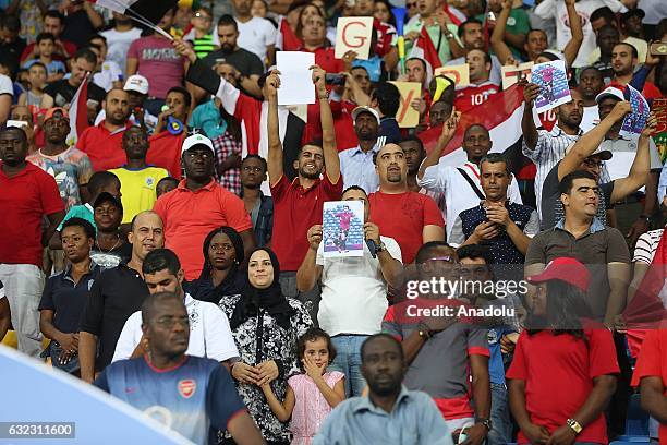 Fans hold photos of former footballer Mohamed Aboutrika during the African Cup of Nations 2017, Group D football match between Egypt and Uganda at...