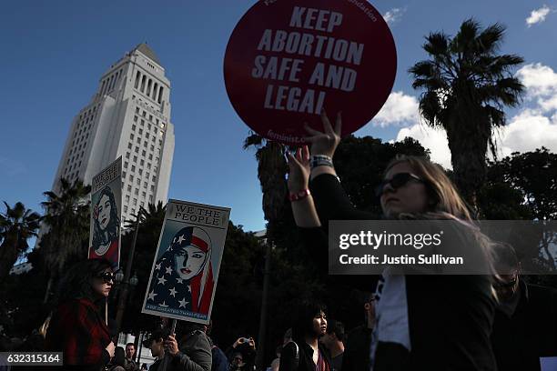 Marchers hold signs during the Women's March on January 21, 2017 in Los Angeles, California. Tens of thousands of people took to the streets of...