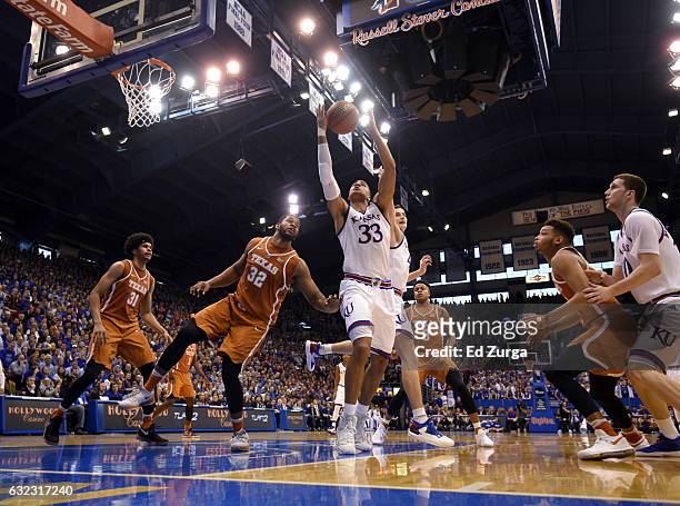 Landen Lucas of the Kansas Jayhawks rebounds against Jarrett Allen and Shaquille Cleare of the Texas Longhorns in the first half at Allen Field House...