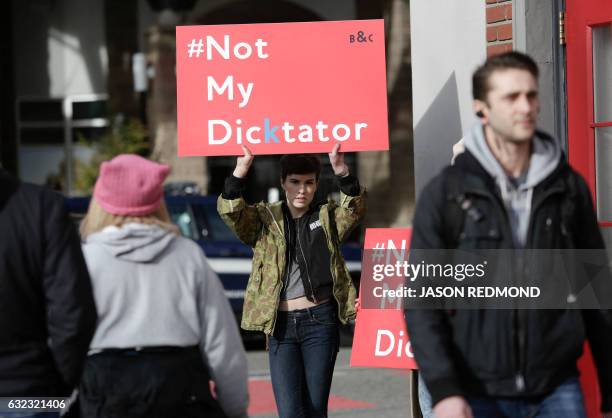 Woman holds a sign as people participate in the Women's March in Seattle, Washington on January 21, 2017. - Led by women in pink "pussyhats,"...