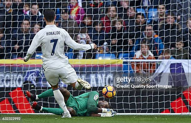 Cristiano Ronaldo of Real Madrid competes for the ball with Carlos Kameni of Malaga during the La Liga match between Real Madrid CF and Malaga CF at...