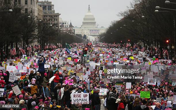 Protesters walk during the Women's March on Washington, with the U.S. Capitol in the background, on January 21, 2017 in Washington, DC. Large crowds...