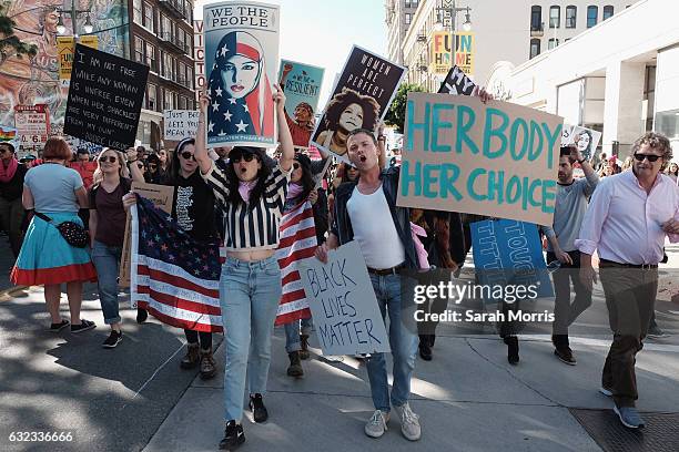 Marchers hold signs during the Women's March on January 21, 2017 in Los Angeles, California. Tens of thousands of people took to the streets of...