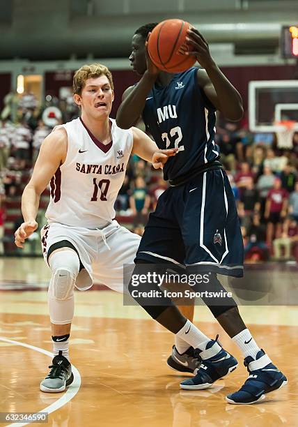 Loyola Marymount Lions guard Buay Tuach is guarded closely by Santa Clara Broncos guard Kai Healy during the regular season game between Santa Clara...