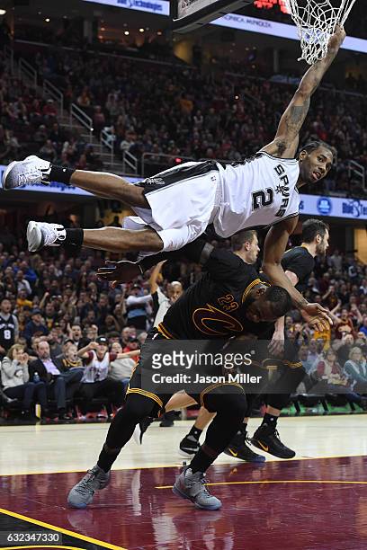 Kawhi Leonard of the San Antonio Spurs hangs on the net to avoid landing on LeBron James of the Cleveland Cavaliers during overtime at Quicken Loans...