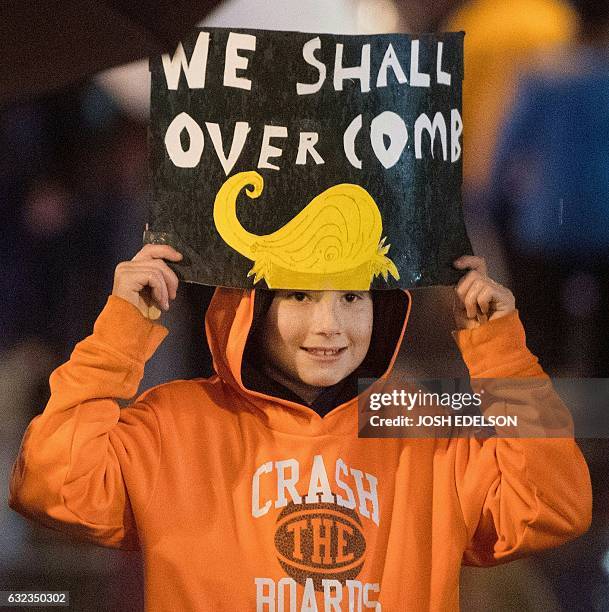 Ollie Iverson holds up a sign during a march down Market Street to protest President Donald Trump and to show support for women's rights in San...