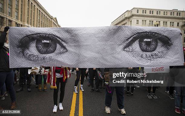 For marchers attending the Women's March on Washington hold up a photograph from the French art project 'Inside Out' by artist JR on January 21, 2017...