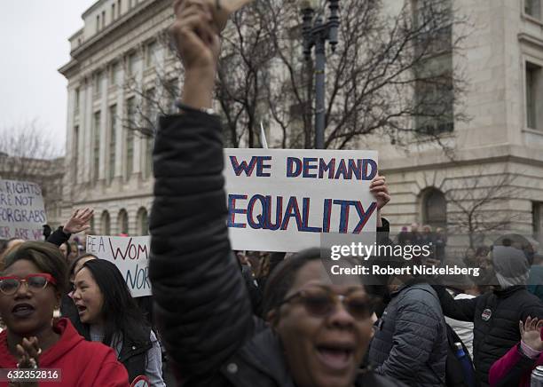 Marchers attending the Women's March on Washington hold up a pro-equality sign on January 21, 2017 in Washington, DC.