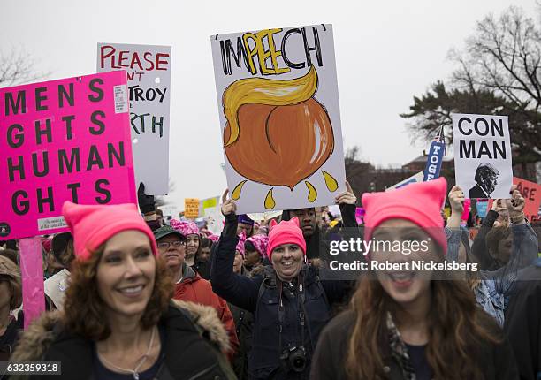 Marchers attending the Women's March on Washington carry signs critical of President Donald Trump on January 21, 2017 in Washington, DC. President...