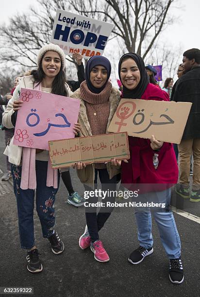 Three marchers originally from Bahrain attending the Women's March on Washington hold up signs which read "I'm a free woman" in Arabic on January 21,...