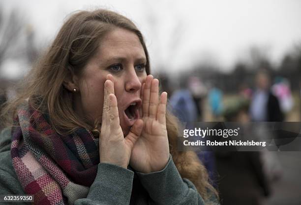 Marcher attending the Women's March on Washington shouts encouraging words to others carrying signs promoting women's rights on January 21, 2017 in...