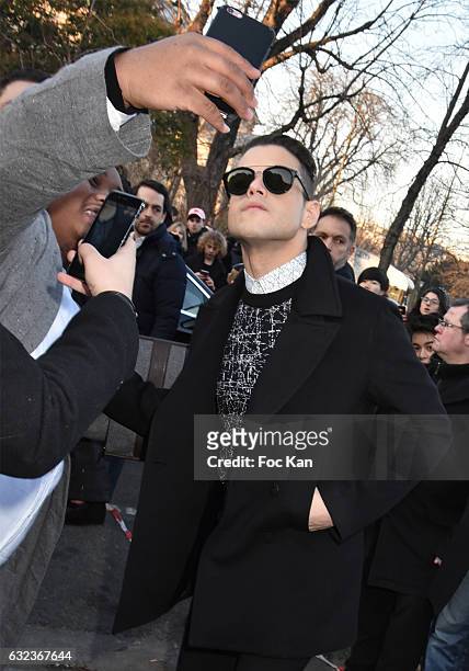 Rami Malek poses for a selfie with a fan the Dior Homme Menswear Fall/Winter 2017-2018 show as part of Paris Fashion Week on January 21, 2017 in...
