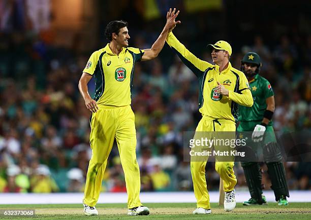 Mitchell Starc of Australia celebrates with Steve Smith after taking the wicket of Umar Akmal of Pakistan during game four of the One Day...