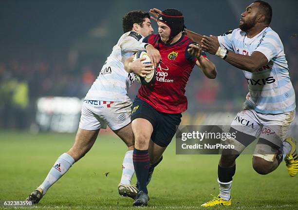 Tyler Bleyendaal of Munster tackled by Etienne Dussartre and Leone Nakarawa of Racing during the European Rugby Champions Cup Round 6 match between...