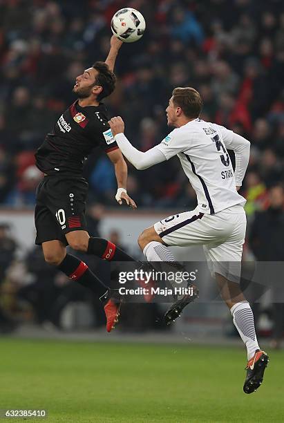 Hakan Calhanoglu of Leverkusen is challenged by Niklas Stark of Berlin during the Bundesliga match between Bayer 04 Leverkusen and Hertha BSC at...