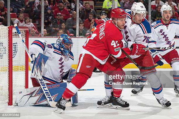 Luke Glendening of the Detroit Red Wings battles for position in front of the net with Brady Skjei of the New York Rangers while screening the view...