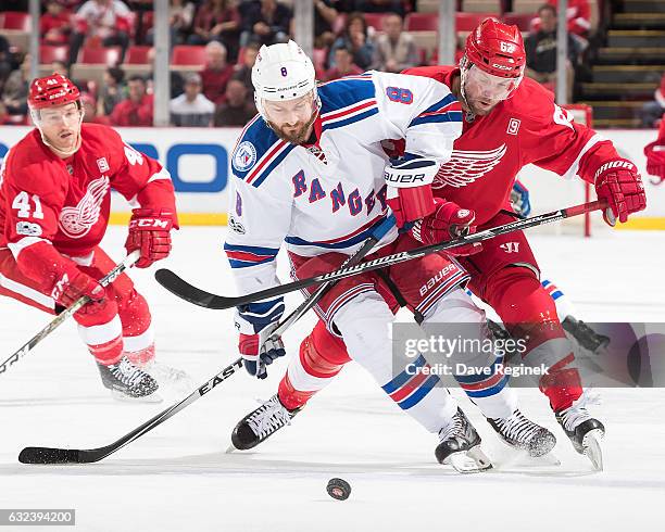 Kevin Klein of the New York Rangers skates after a loose puck in front of Thomas Vanek of the Detroit Red Wings during an NHL game at Joe Louis Arena...