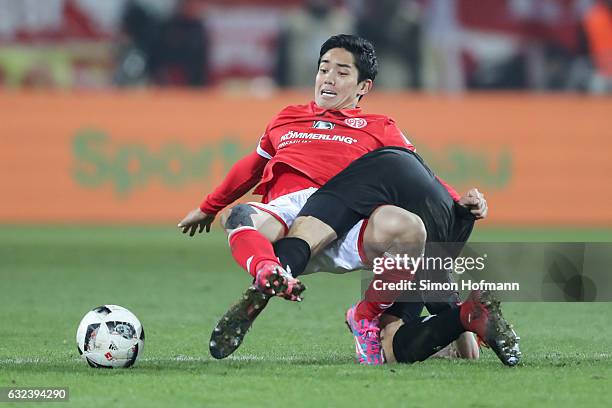 Yoshinori Muto of Mainz is challenged by Jonas Hector of Koeln during the Bundesliga match between 1. FSV Mainz 05 and 1. FC Koeln at Opel Arena on...