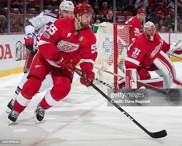 Niklas Kronwall of the Detroit Red Wings skates with the puck past teammate goaltender Jared Coreau followed by Rick Nash of the New York Rangers...