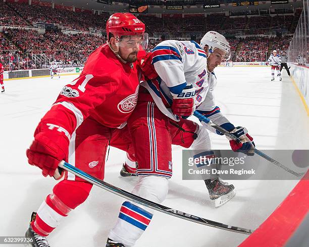 Kevin Hayes of the New York Rangers battles along the boards with Xavier Ouellet of the Detroit Red Wings during an NHL game at Joe Louis Arena on...