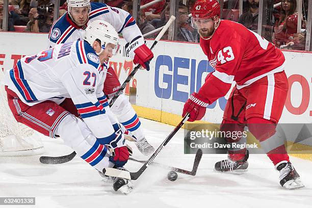 Ryan McDonagh of the New York Rangers skates in after the puck with Darren Helm of the Detroit Red Wings during an NHL game at Joe Louis Arena on...