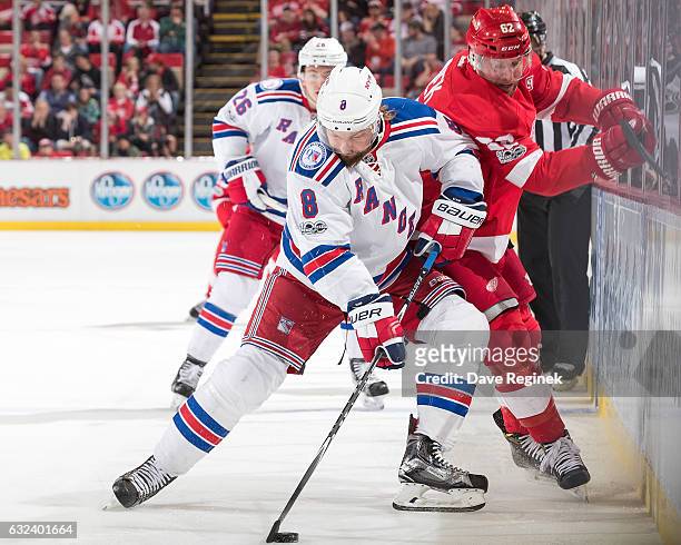 Kevin Klein of the New York Rangers skates with the puck along the boards followed by Thomas Vanek of the Detroit Red Wings during an NHL game at Joe...