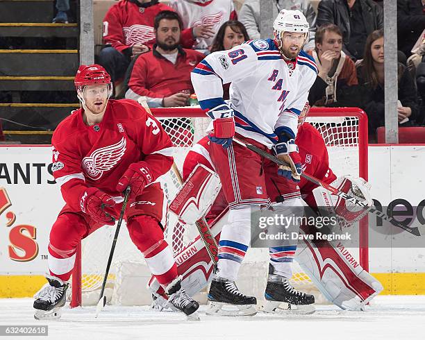 Rick Nash of the New York Rangers screens the view of goaltender Jared Coreau of the Detroit Red Wings while being defended by Nick Jensen of the...