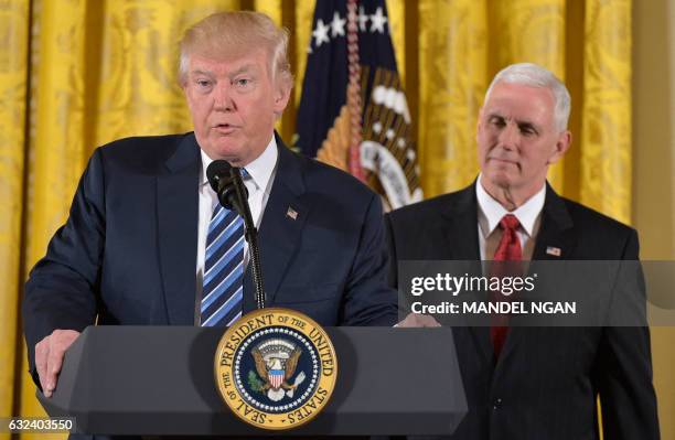 President Donald Trump speaks, as Vice President Mike Pence watches, before the swearing in of the White House senior staff at the White House on...