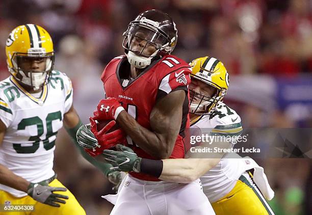 Julio Jones of the Atlanta Falcons is hit by Jake Ryan of the Green Bay Packers in the first quarter in the NFC Championship Game at the Georgia Dome...