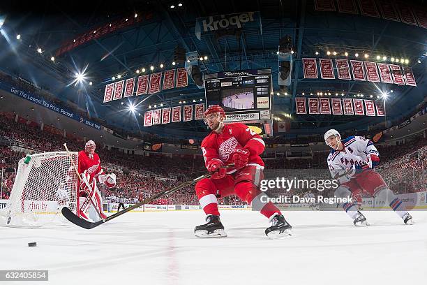 Mike Green of the Detroit Red Wings skates with the puck behind the net followed by Derek Stepan of the New York Rangers during an NHL game at Joe...