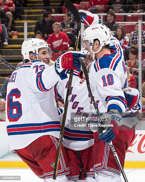 Miller of the New York Rangers celebrates his overtime goal with teammates Brady Skjei and Mats Zuccarello during an NHL game against the Detroit Red...