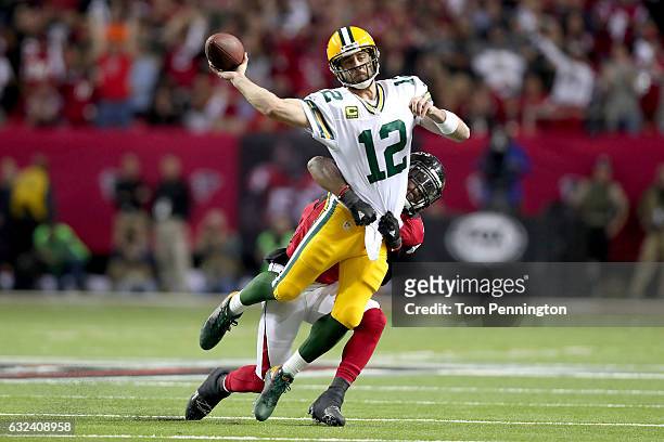 Aaron Rodgers of the Green Bay Packers throws as he is hit by Deion Jones of the Atlanta Falcons in the first quarter in the NFC Championship Game at...