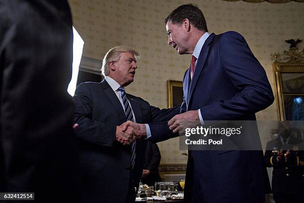 President Donald Trump shakes hands with James Comey, director of the Federal Bureau of Investigation , during an Inaugural Law Enforcement Officers...