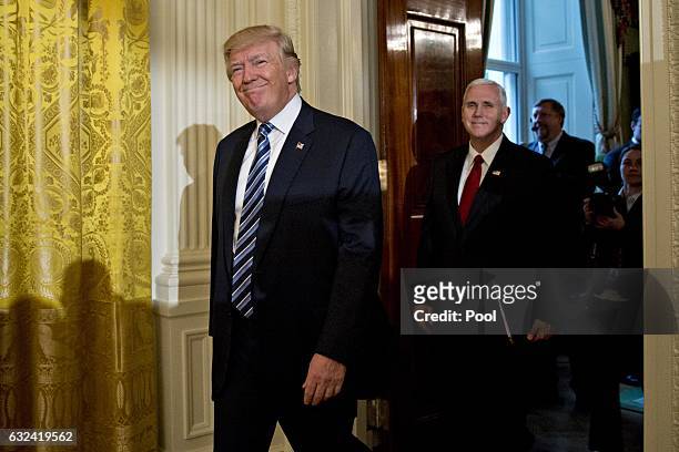 President Donald Trump and U.S. Vice President Mike Pence arrive to a swearing in ceremony of White House senior staff in the East Room of the White...