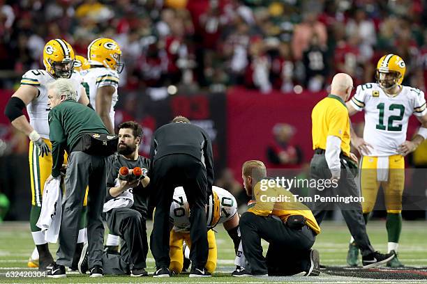 Lang of the Green Bay Packers receives treatment on the field in the second half against the Atlanta Falcons in the NFC Championship Game at the...