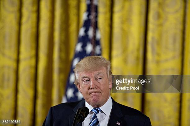 President Donald Trump pauses while speaking during a swearing in ceremony of White House senior staff in the East Room of the White House on January...