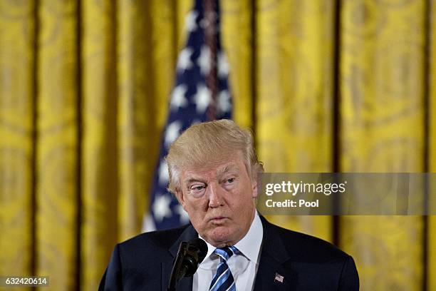 President Donald Trump pauses while speaking during a swearing in ceremony of White House senior staff in the East Room of the White House on January...