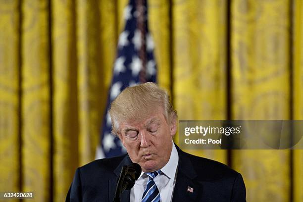 President Donald Trump pauses while speaking during a swearing in ceremony of White House senior staff in the East Room of the White House on January...