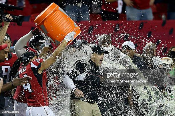Head coach Dan Quinn of the Atlanta Falcons has gatorade dumped on him by his team late in the game against the Green Bay Packers in the NFC...