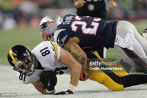 Jesse James of the Pittsburgh Steelers is tackled by Patrick Chung of the New England Patriots during the second quarter in the AFC Championship Game...