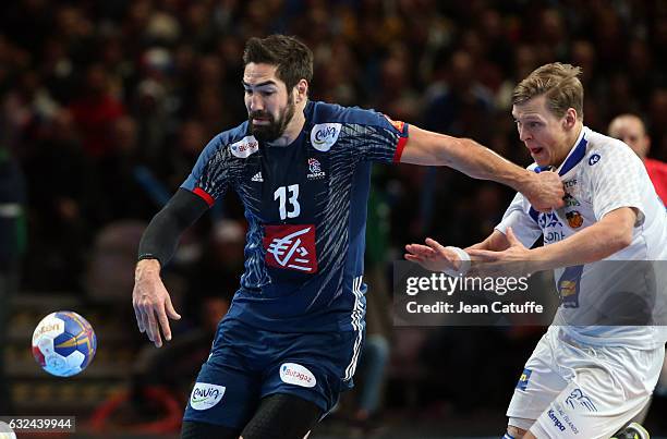 Nikola Karabatic of France and Janus Dadi Smarason of Iceland in action during the 25th IHF Men's World Championship 2017 Round of 16 match between...