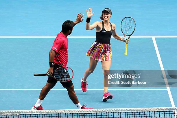 Martina Hingis of Switzerland and Leander Paes of India celebrate winning a point in their second round mixed doubles match against Casey Dellacqua...