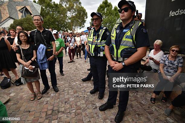Members of the public and police attend a vigil in memory of victims who were mown down by a 26-year-old man driving a car, at Federation Square in...