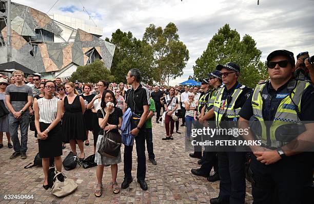 Members of the public and police attend a vigil in memory of victims who were mown down by a 26-year-old man driving a car, at Federation Square in...