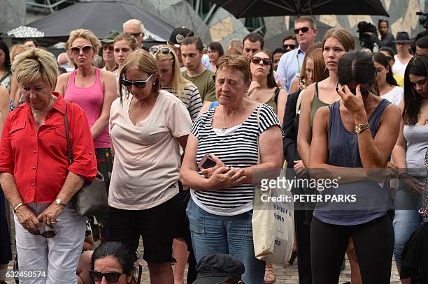 Members of the public attend a vigil in memory of victims who were mown down by a 26-year-old man driving a car, at Federation Square in Melbourne on...