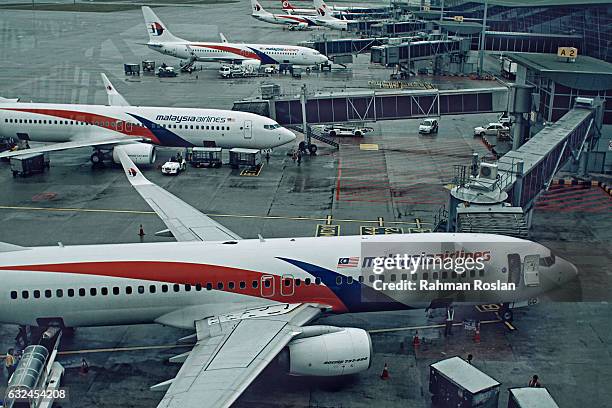 Malaysian Airlines aircrafts are seen at the busy terminal of Kuala Lumpur International airport on January 23, 2017 in Sepang, Malaysia. The...