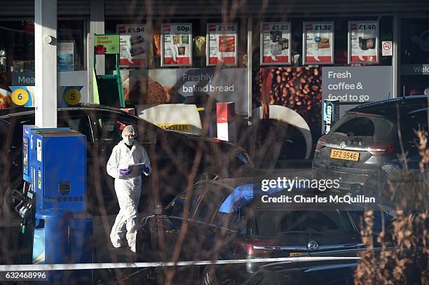 Forensic officer examines the scene of the shooting of a PSNI officer at a petrol station on the Crumlin road on January 23, 2017 in Belfast,...