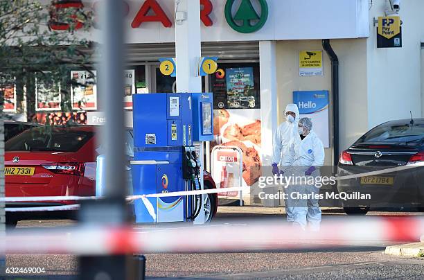 Forensic officers examine the scene of the shooting of a PSNI officer at a petrol station on the Crumlin road on January 23, 2017 in Belfast,...