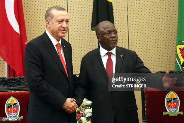 Turkish President Recep Tayyip Erdogan shakes hands with Tanzania's President John Pombe Joseph Magufuli following their joint press conference at...